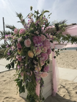 Dit prieel met grote bloemstukken geven een prachtige romantische look op het strand. Compleet verzorgd door Bruidsboeket & Zo & bloembinderij van der Maat Strandbruiloft prieeltje