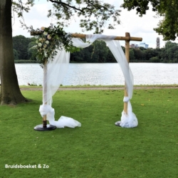 Bloemstuk op een prieeltje. Wij maken een prachtig bloemstuk voor jullie huwelijksdag. Dit bamboe prieel is niet te huur bij Bruidsboeket & Zo! bloemstuk-trouwboog-ceremonie-bloemboog